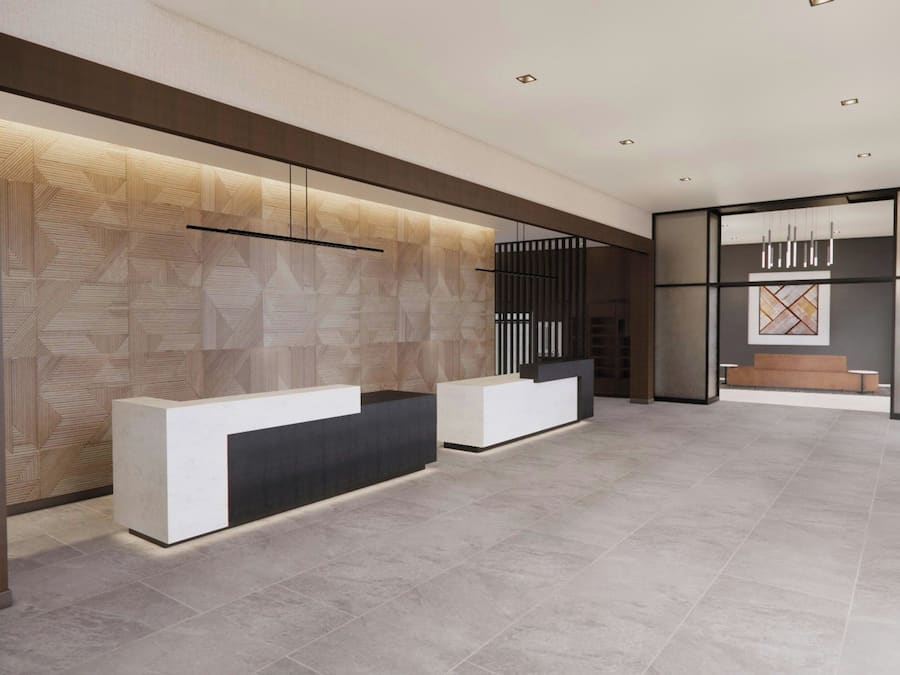 A reception area with a modern design, featuring a patterned wall, a reception desk, and a seating area with a sofa and chairs.