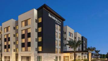 Un moderno edificio de hotel con un llamativo letrero de 'Residence Inn by Marriott', varios pisos y una zona de entrada bien iluminada.