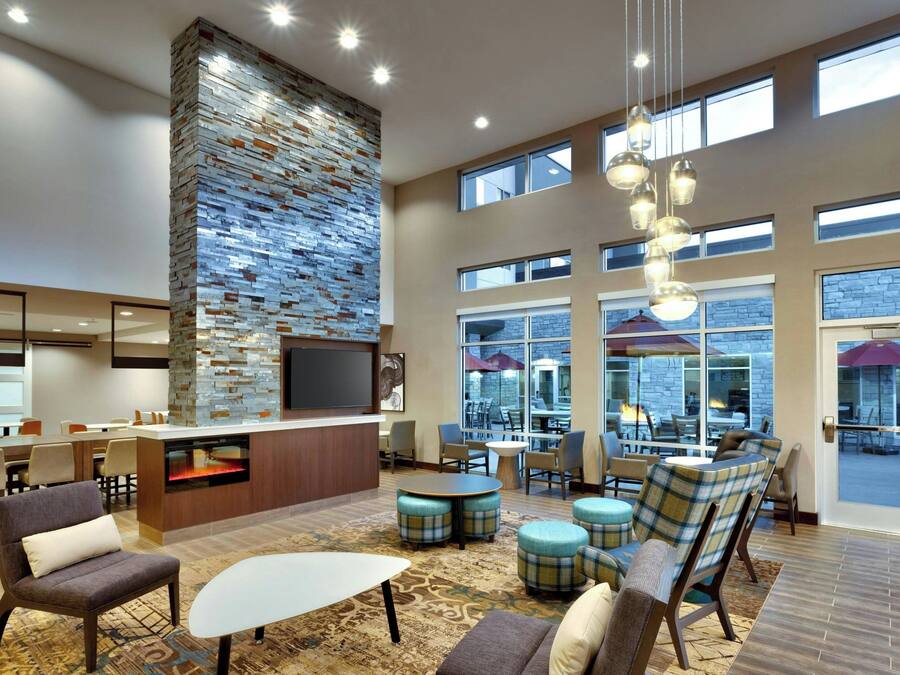 A spacious lobby with a stone accent wall, a bar area, and seating arrangements.