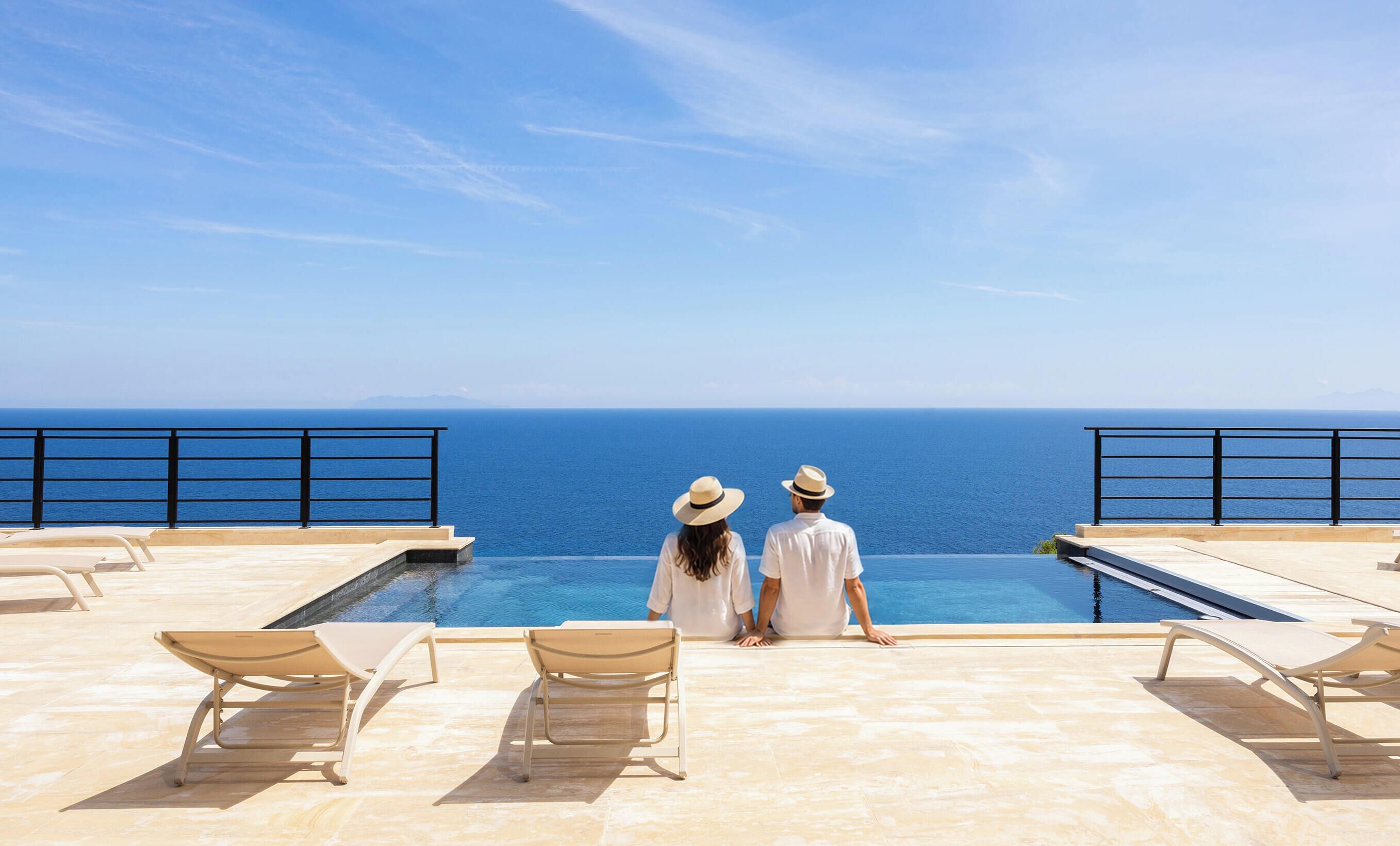 Um casal em uma piscina com vista para o mar.