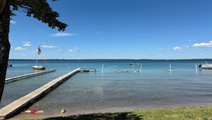 Un rivage paisible avec un quai, des bateaux et un ciel dégagé.