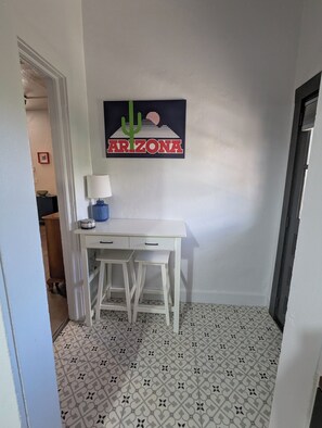 Ein Zimmer mit Schreibtisch, Lampe und einem an der Wand befestigten Schild mit der Aufschrift 'ARIZONA'.