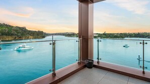 Un balcó amb vista a un riu, embarcacions i una riba llunyana.