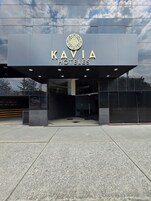 The exterior of KAVIA HOTELS with a modern design, featuring a large logo above the entrance and a reflective glass facade.