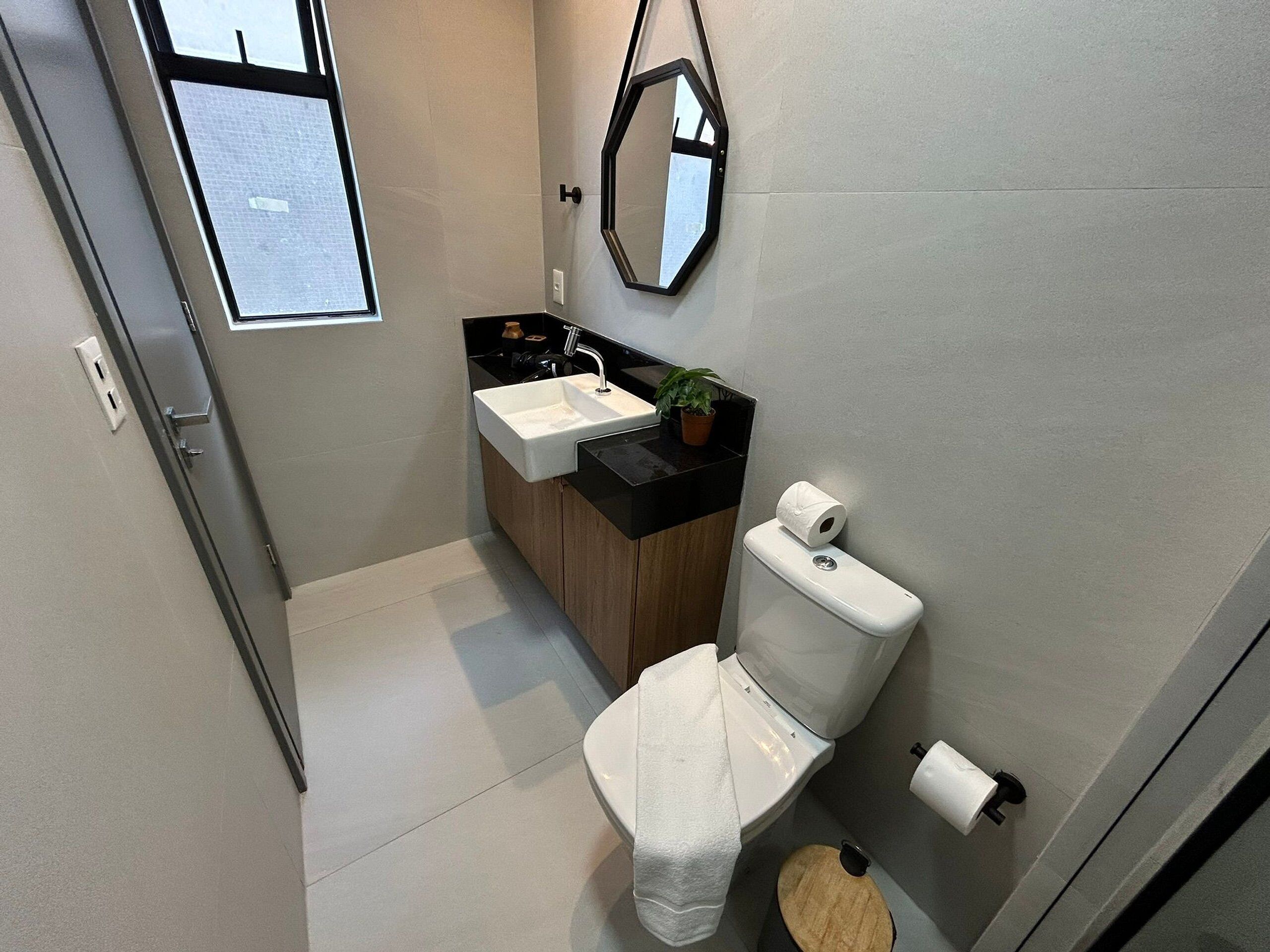 A modern bathroom with a toilet, sink, and mirror.