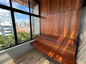 Ein Balkon mit Holzboden und Blick auf Stadtgebäude.