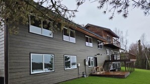 A two-story building with a flat roof, large windows, and a deck. - Jerry's Lake House Unit 1 on Denise Lake, Soldotna (Soldotna)