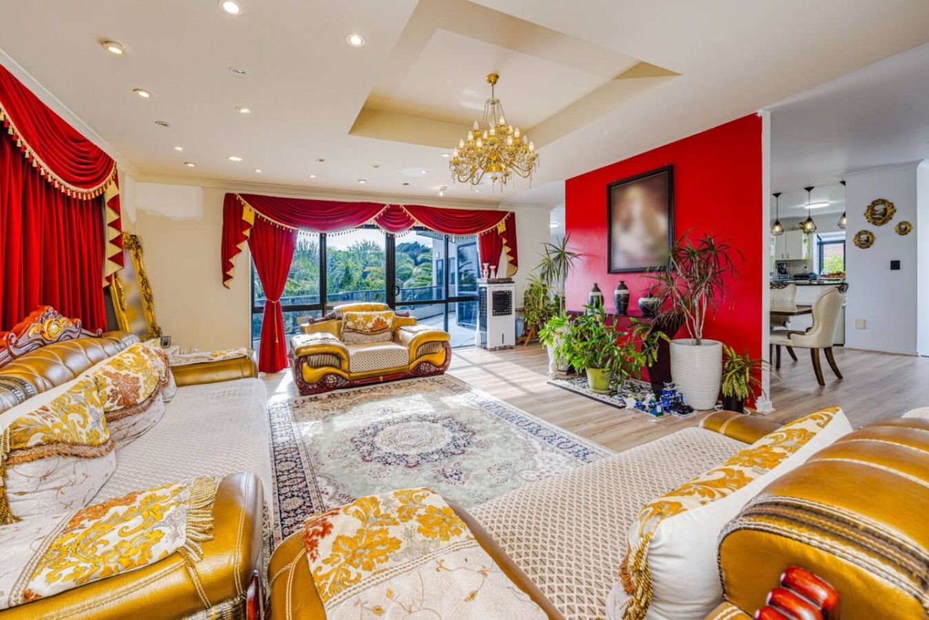 Uma sala de estar luxuosa com um amplo sofá, um candelabro e vista para o exterior.