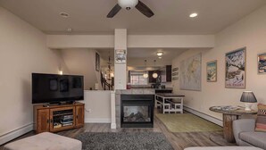 A living room with a fireplace, a television, and a dining area. - Girdwood Mountain Basecamp-Sleeps 7-Near Alyeska (Anchorage)