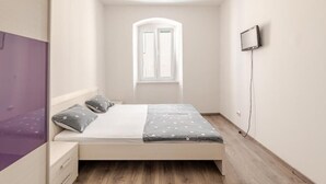 A bedroom with a bed, a window, a TV, and a wardrobe. - Perfect 2-bedroom apartment with AC in charming Split (Split)