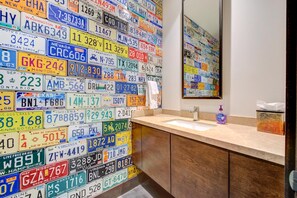 A bathroom with a wall of various state license plates, a sink, and a mirror. - KBM Resorts | Walk to Slopes, Sports Court, Private Home Theater, Sleeps 16, Private Hot Tub PCO-184G (Park City)