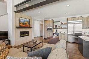 A modern living room with a fireplace, a television, and a sofa. - Keystone Sanctuary 4 Bed 5 Bath Htth (Keystone)