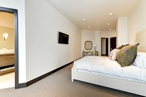 A modern hotel room with a large bed, a vanity with a mirror, and a small seating area. - KBM Resorts| Walk to Slopes, Sports Court, Private Home Theater, Sleeps 17, Outdoor Hot Tub PCO-184M (Park City)