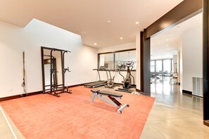 A spacious gym with cardio machines, a pull-up bar, and a bench. - KBM Resorts| Walk to Slopes, Sports Court, Private Home Theater, Sleeps 17, Outdoor Hot Tub PCO-184M (Park City)