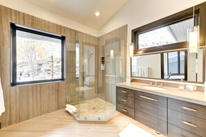 A modern bathroom with a glass-enclosed shower, wooden paneling, a large mirror, and a view of trees outside. - KBM Resorts| Walk to Slopes, Sports Court, Private Home Theater, Sleeps 17, Outdoor Hot Tub PCO-184M (Park City)