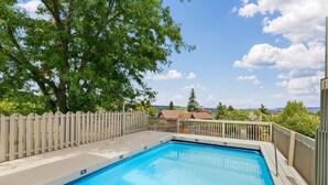 Piscina rectangular con plataforma de madera y cerca de piquetes blancos.