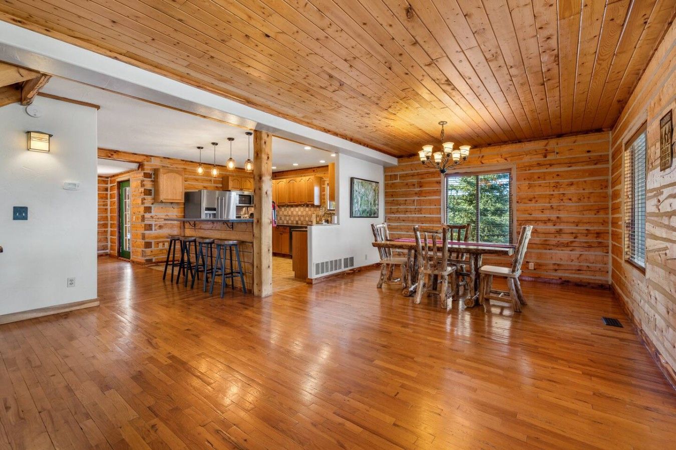 A spacious kitchen with wooden cabinets, a central island, and bar stools.