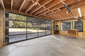 Un garage doté d’une grande porte coulissante, d’un sol en béton et d’un intérieur en bois.