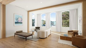 Un salon spacieux avec un canapé moderne, un banc en cuir marron et une table basse.