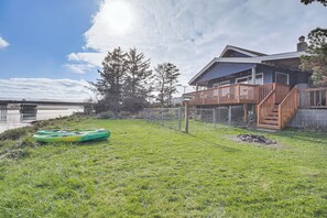 Una casa con un balcón, un kayak y vista al agua.