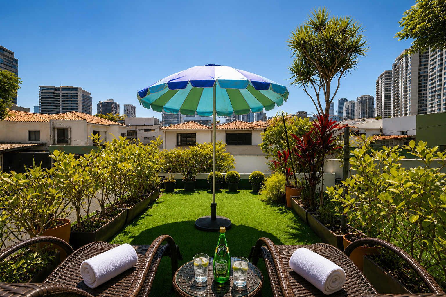 A rooftop garden with a green lawn, potted plants, wicker furniture, and a striped umbrella.