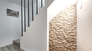 Uma escadaria com design moderno, uma parede texturizada e um quadro emoldurado na parede.