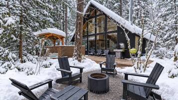 Deck with fire pit seating under the trees.