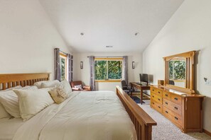 A bedroom with a bed, a desk, a chair, a dresser, and a window with curtains. - 3 King Beds + Hot Tub + Game Room • Sleeps 12 (Rhododendron)