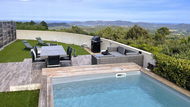 Una piscina al terrat amb vistes a l'entorn natural, mobles d'exterior i zona de barbacoa.