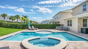 A swimming pool with lounge chairs, a hot tub, and a well-maintained lawn. - Family Vacation Home Near Disney - Pool & Spa (Kissimmee)