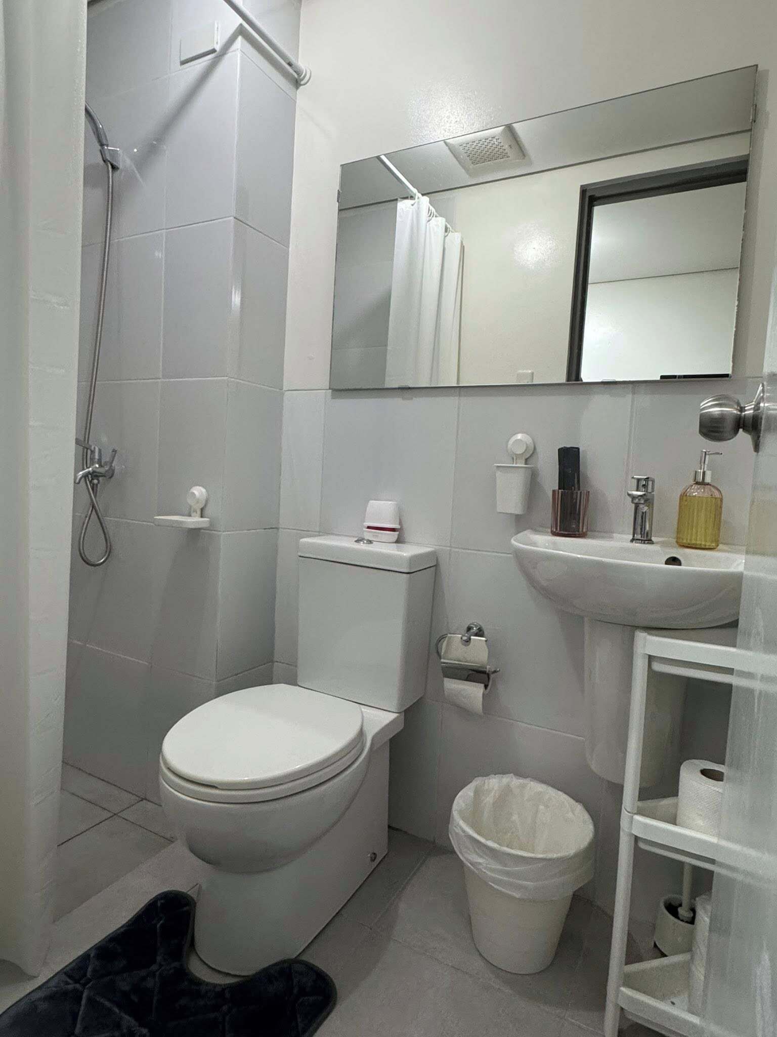 Ein Badezimmer mit Toilette, Bidet, Dusche, Waschbecken und Spiegel.