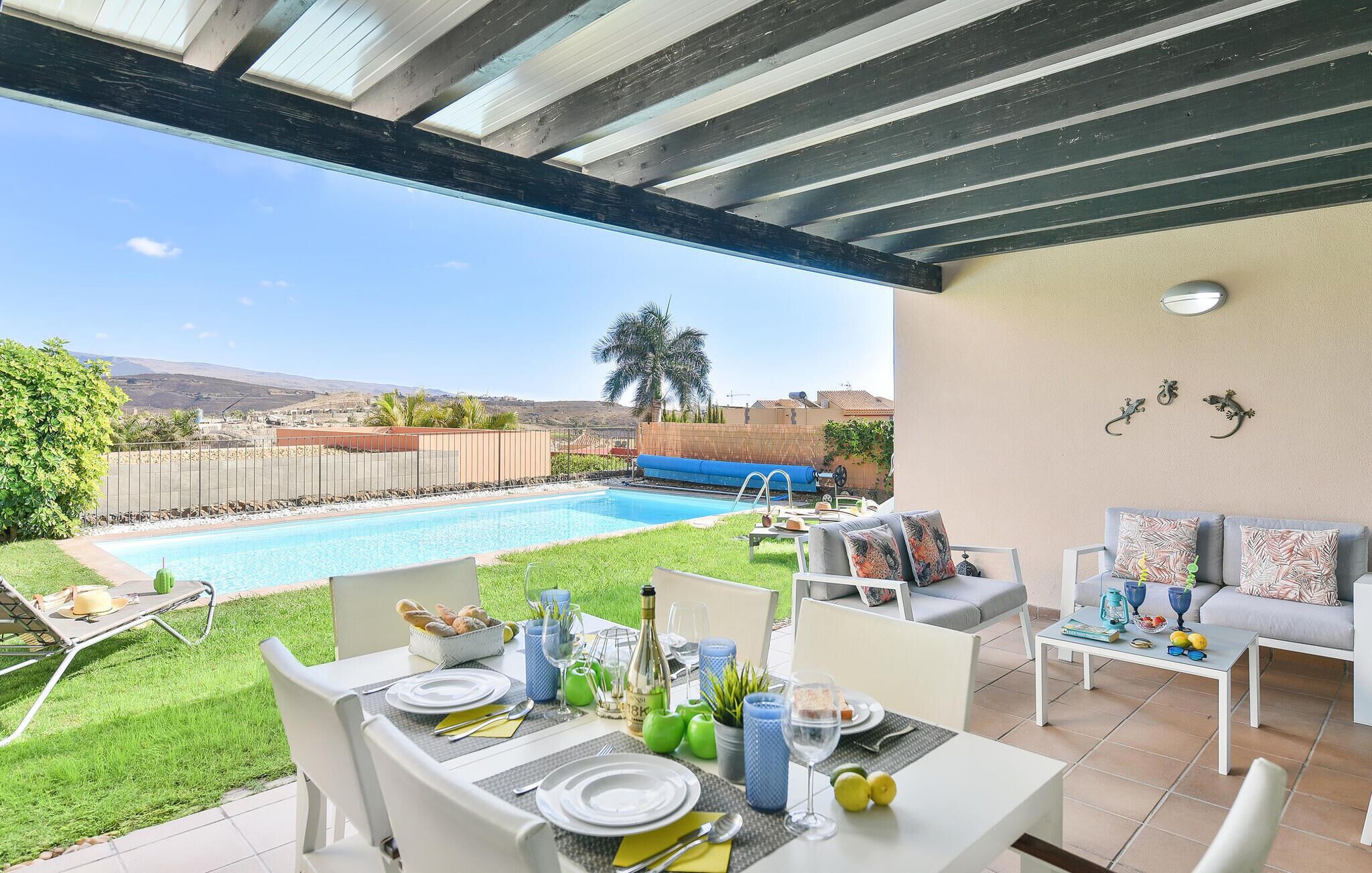 Eine Terrasse im Freien mit Pool, Essbereich und Blick auf die Landschaft.