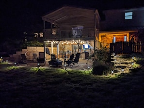 Una casa con un patio techado, mobiliario exterior y una parrilla.