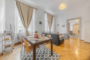 Ein modernes Wohnzimmer mit Essbereich, einer Couch und einer Küchenzeile.