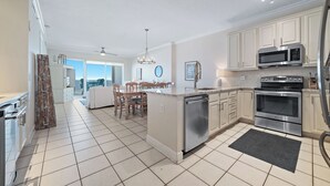 Een moderne keuken met witte kastjes, roestvrijstalen apparatuur en een groot eiland.
