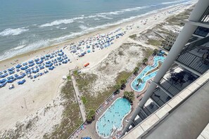 Una playa con muchos sombrillas y una piscina.