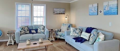 A living room with two sofas, a coffee table, and a ceiling fan.