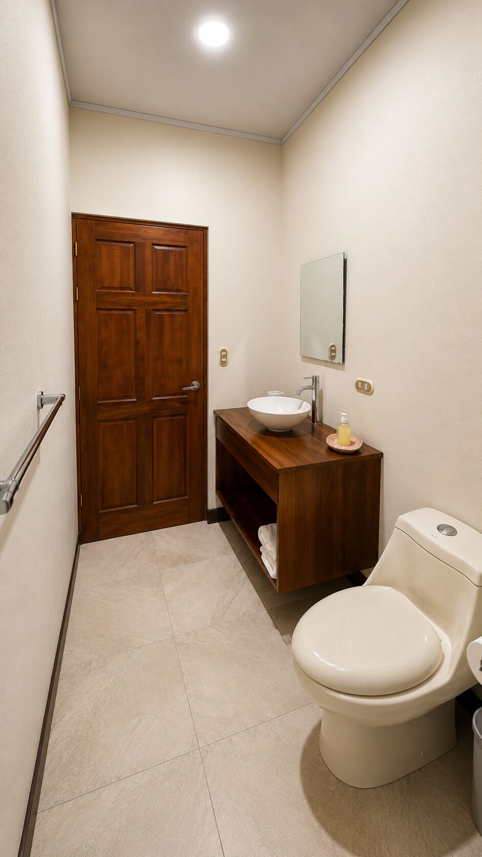 Ein Badezimmer mit Holztür, Waschbecken, Spiegel und Toilette.