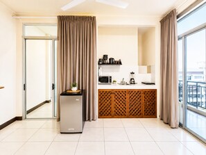 A modern kitchen with a refrigerator, microwave, and coffee maker. - Aparta hotel puerta del cielo  (Quepos)
