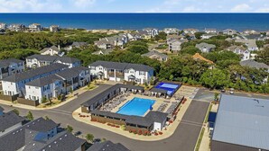 Zona residencial con piscina, casas y vista al océano.
