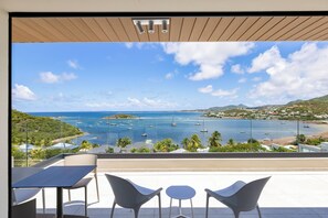 Ein Balkon mit Blick aufs Meer, inklusive Tisch und zwei Stühlen.