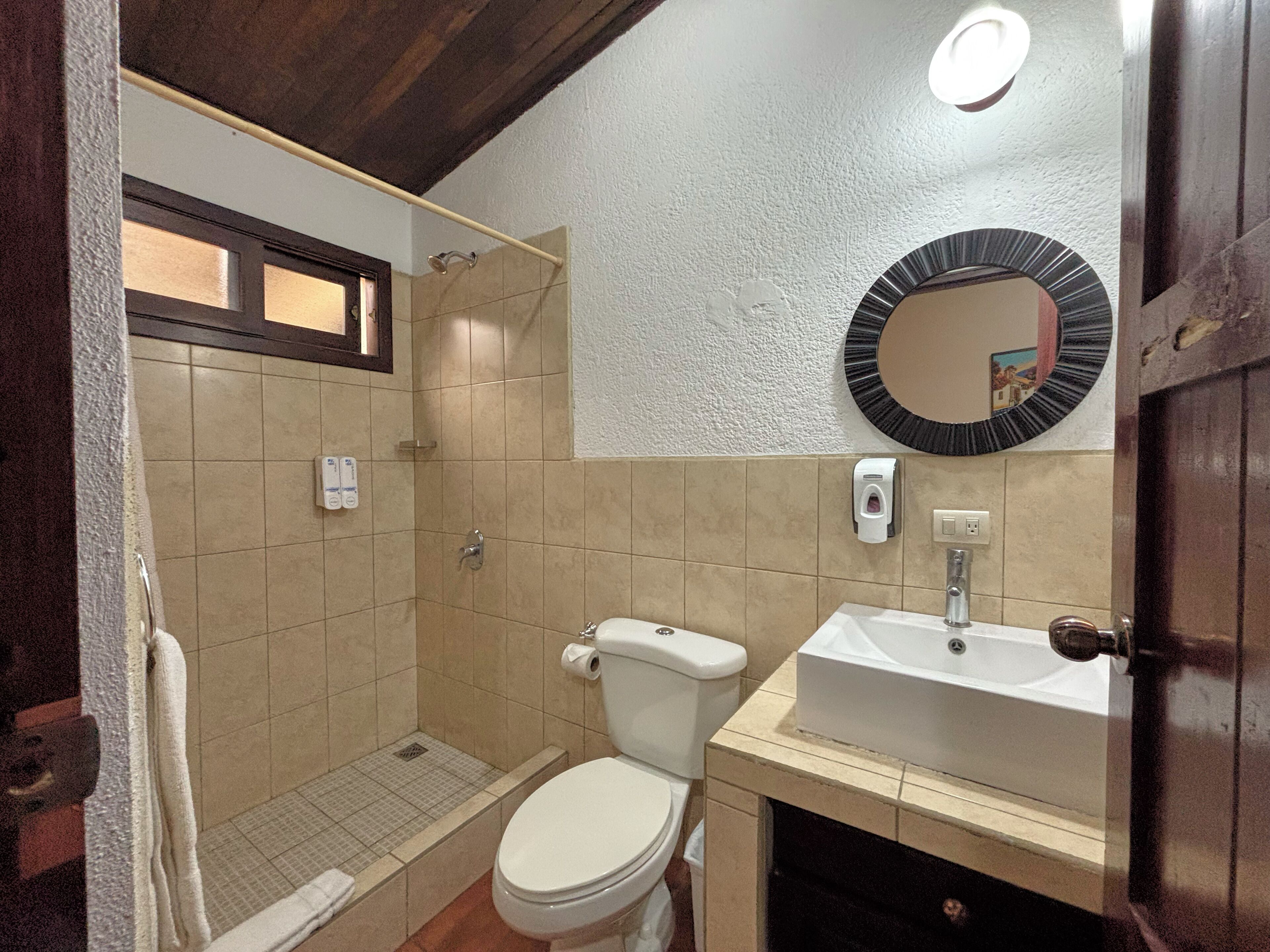Une salle de bain avec des toilettes, un lavabo et une douche.