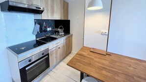 Een moderne keuken met een inbouwoven, een spoelbak en een houten tafel.