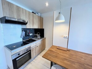 Eine moderne Küche mit Einbauofen, Spüle und einem Holztisch.