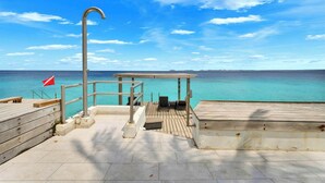 A wooden deck with a metal railing, a flag, and a bench. - Apartment Belmar 6 with a beautiful view and refreshing shared pool (Kralendijk)