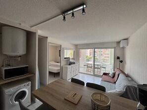 A compact living space with a kitchenette, a dining area, a sofa, and a balcony with a view. - Lovely 2-room apartment plus cabin with air conditioning, residence with pool, near Richelieu... (LE CAP D AGDE)