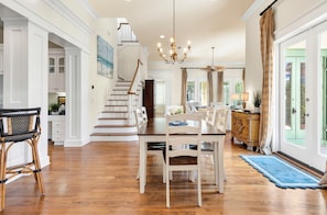 Eine geräumige Küche mit Essbereich, Holzböden und einem Chandelier.