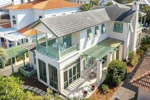 A two-story house with a balcony, large windows, and a patio area. - Casa Del Mare Caribe (Miramar Beach)