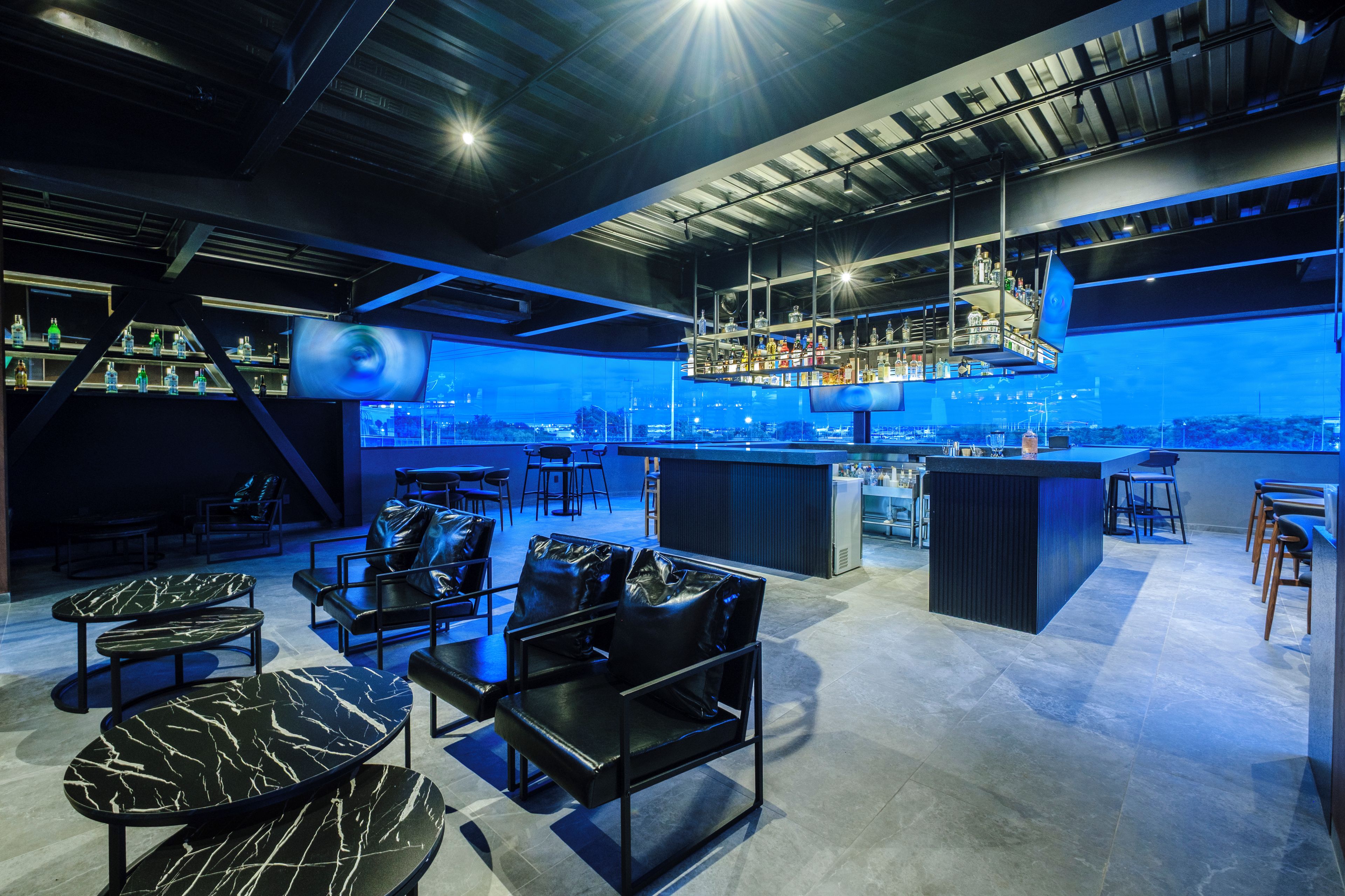 Un área de bar moderna con asientos y una barra.