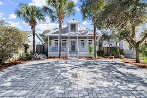 A house with a porch, a bicycle, and a paved driveway. - Bon Villa 102-Golf Cart + Private Pool-Sleeps 10 (Seagrove Beach)